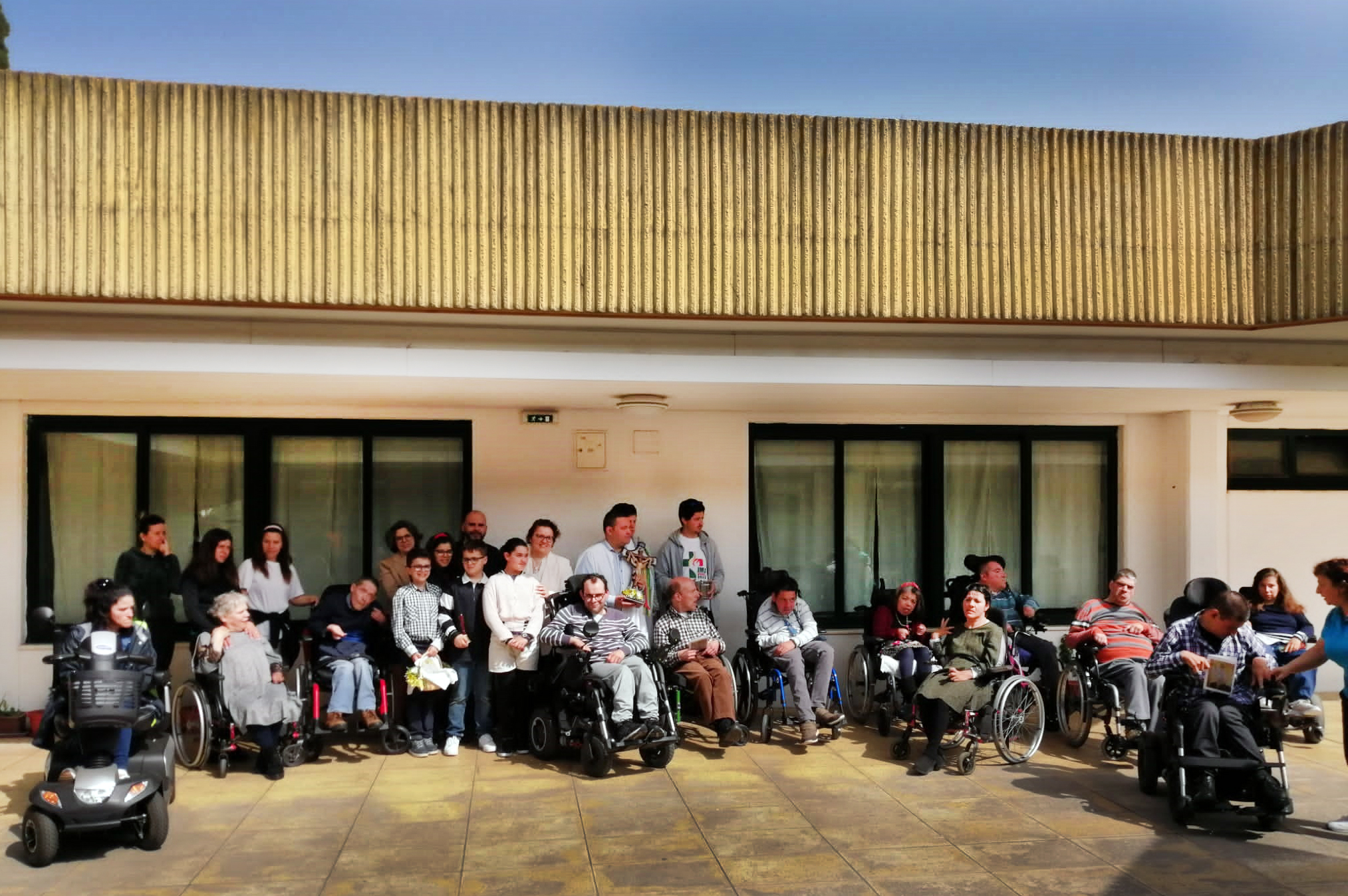 Fotografia de grupo, em zona exterior da Villa Urbana, com perto de três dezenas de pessoas durante a receção à visita Pascal realizada por elementos da Paróquia de Valbom.